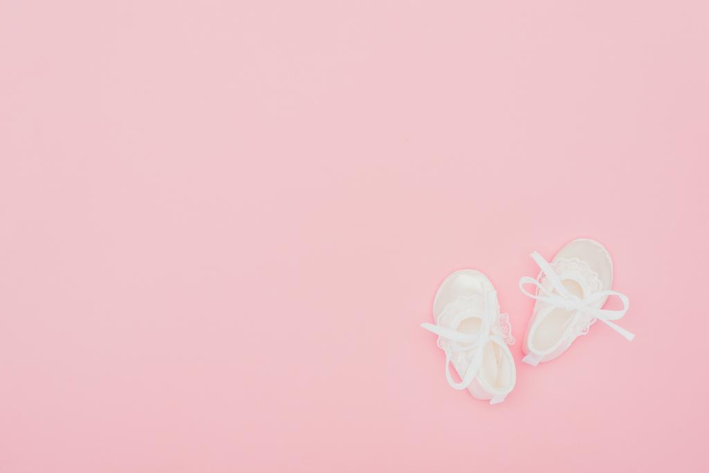 bovenaanzicht van babyslofjes geïsoleerd op roze - Foto, afbeelding