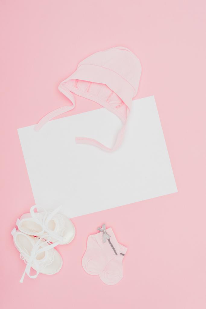 Draufsicht auf leeres Brett mit Babykleidung isoliert auf rosa - Foto, Bild