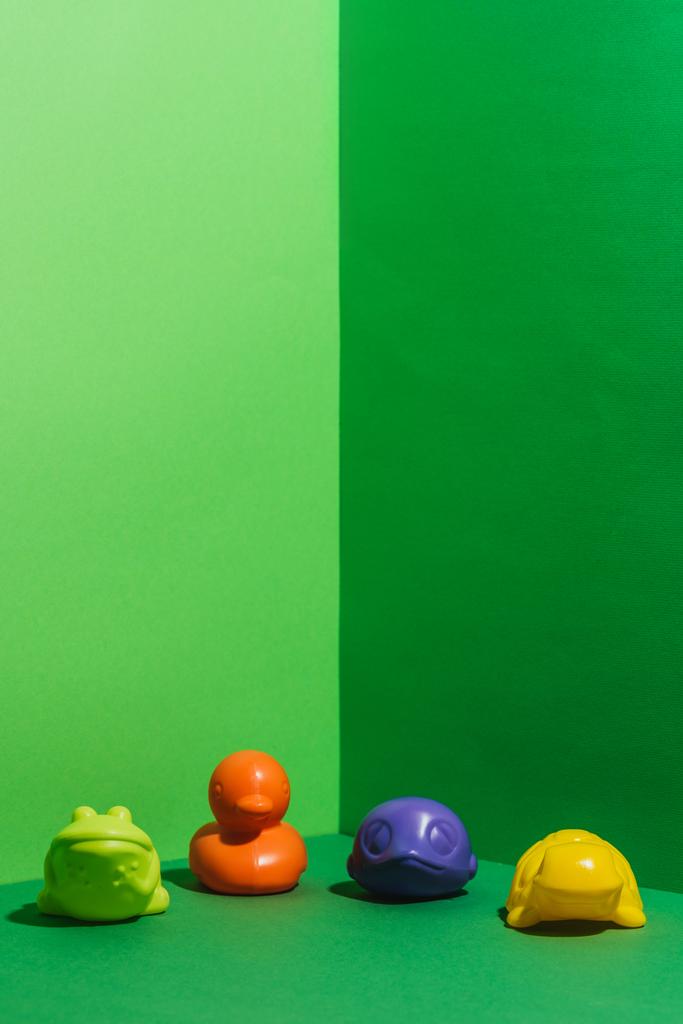 χρωματιστά Βρεφικά παιχνίδια σε σχήμα ζώων στο πράσινο - Φωτογραφία, εικόνα