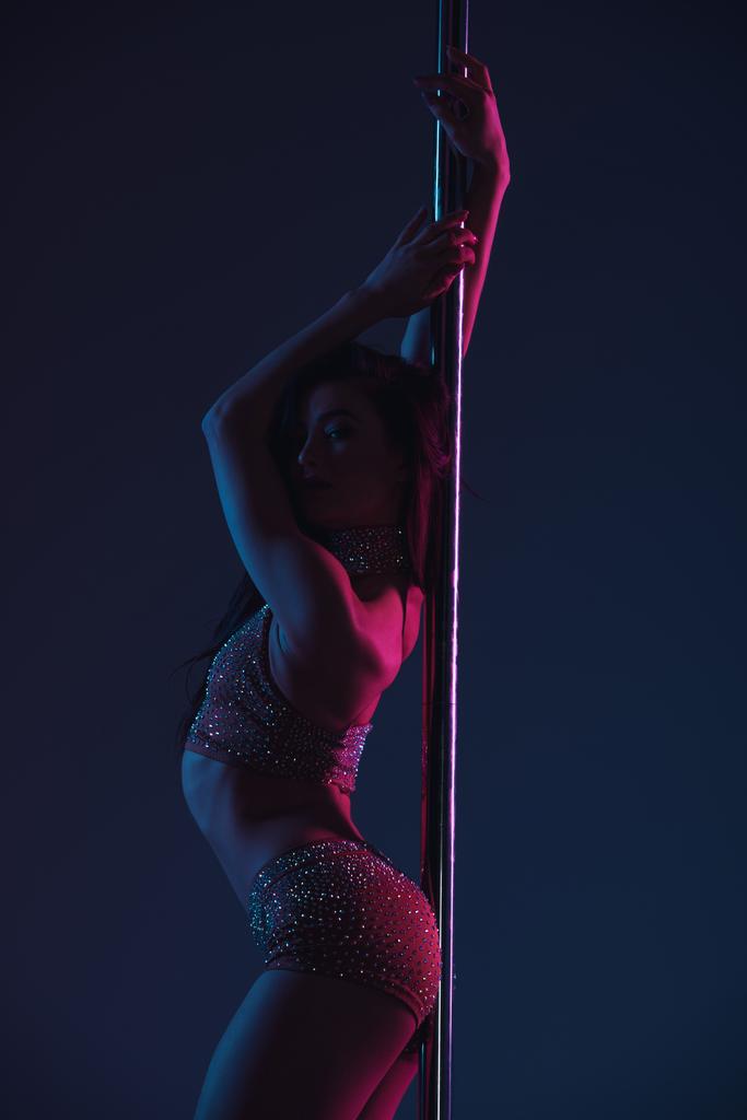 beautiful seductive young woman posing with pole on blue - Photo, Image