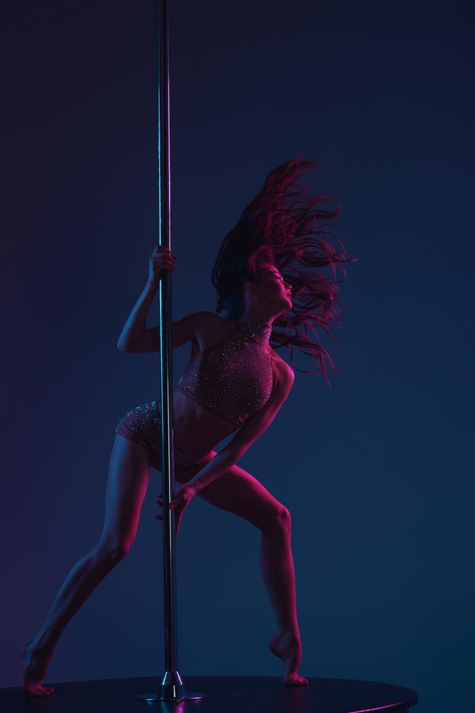 verführerisch athletische Frau tanzt mit Stange auf Blau   - Foto, Bild