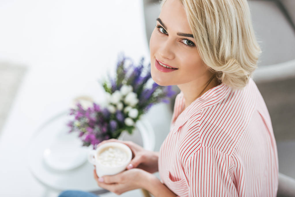 femme blonde souriante tenant une tasse de café
 - Photo, image