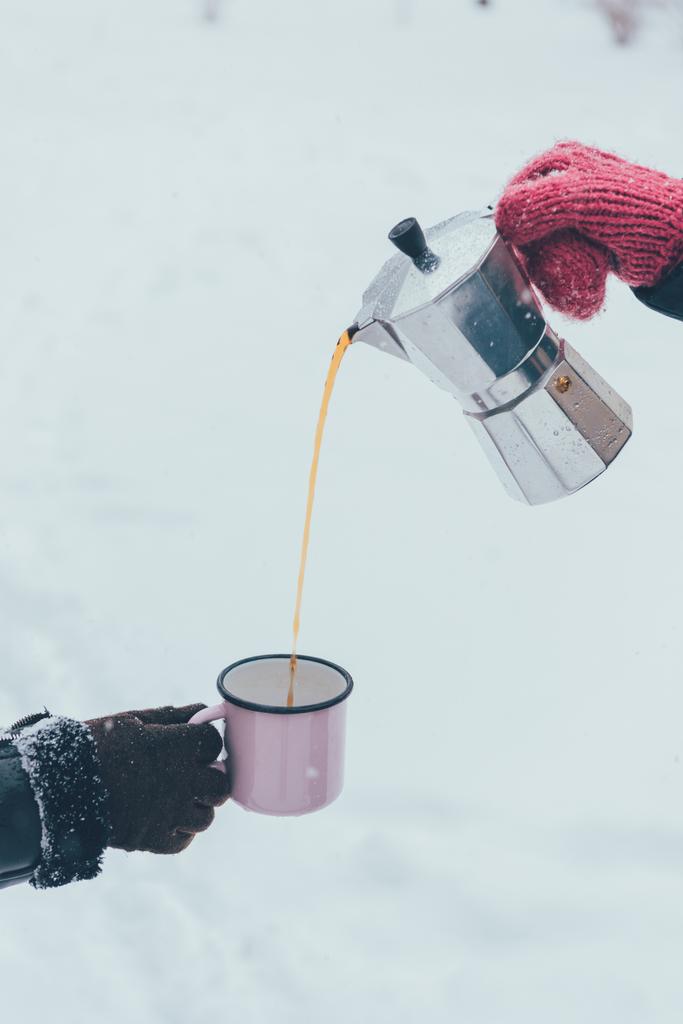 冬の日のカップに熱いコーヒーを注ぐ男の部分的なビュー - 写真・画像