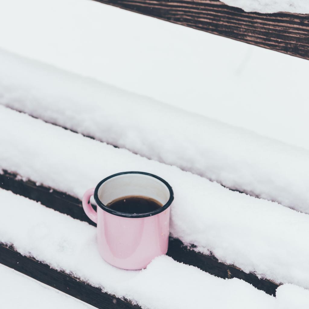 zamknąć widok filiżankę kawy na drewnianej ławce na śniegu - Zdjęcie, obraz