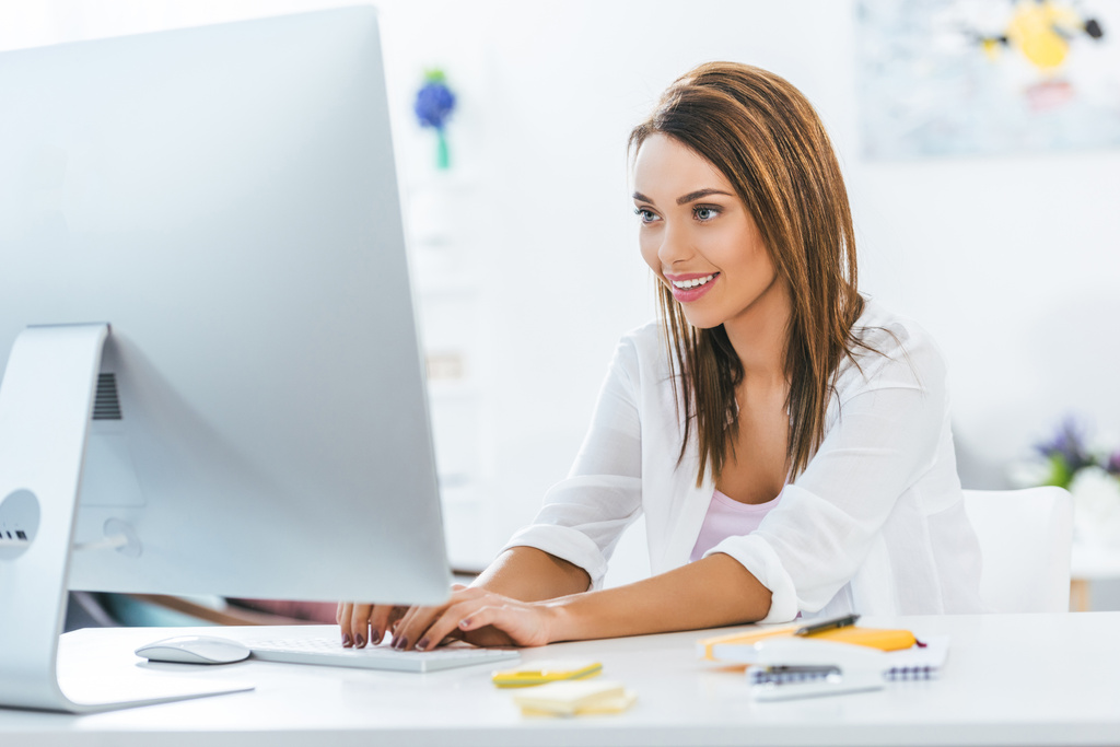 привлекательная счастливая девушка, работающая с компьютером дома
 - Фото, изображение