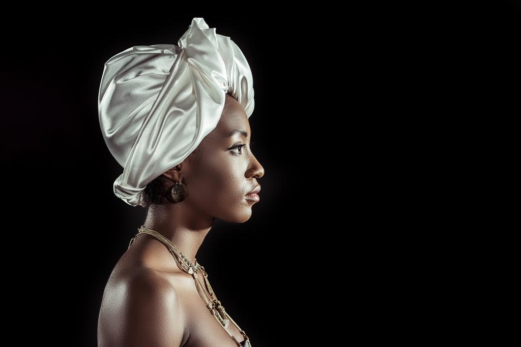 vista lateral da mulher americana africana em envoltório de cabeça de fio branco isolado em preto
 - Foto, Imagem