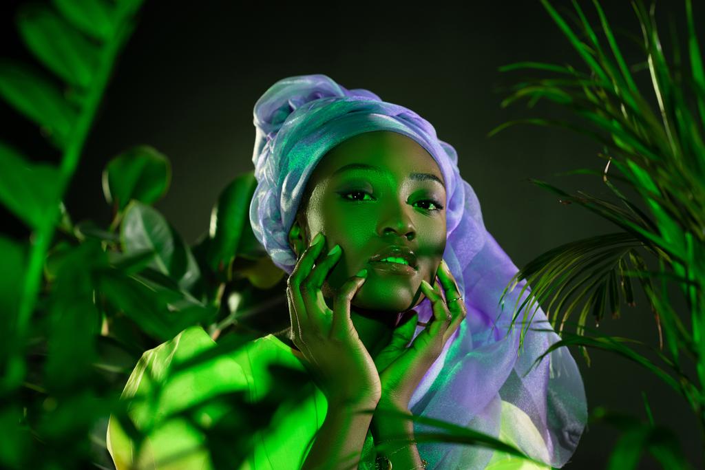 Αισθησιακό αφρικανική αμερικανική γυναίκα στο παραδοσιακό σύρμα κεφάλι τυλίξτε κάτω από το πράσινο φως - Φωτογραφία, εικόνα