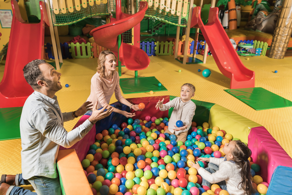 visão de alto ângulo de família feliz jogando com bolas coloridas no centro de entretenimento
  - Foto, Imagem