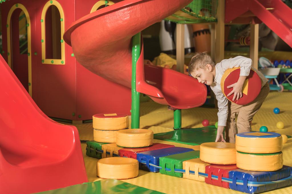 niedliche glückliche kleine Junge spielt mit Blöcken im Spielzentrum - Foto, Bild