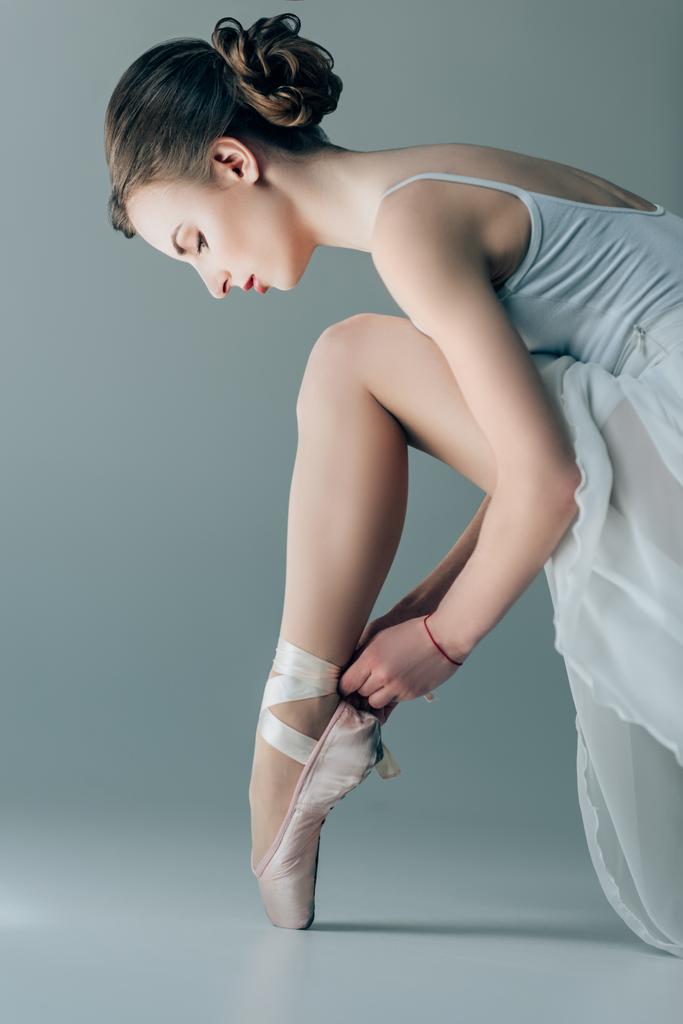 schöne Tänzerin in Ballettschuhen an Füßen, vereinzelt auf grau - Foto, Bild