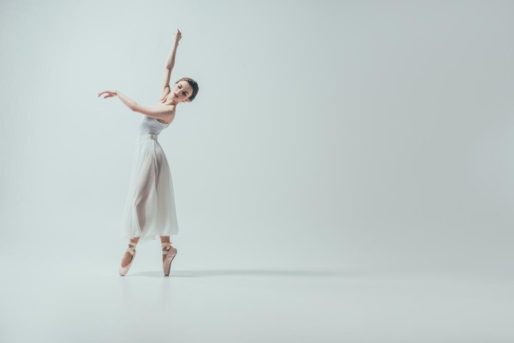 atractiva bailarina en vestido blanco bailando en estudio, aislada en blanco
 - Foto, Imagen