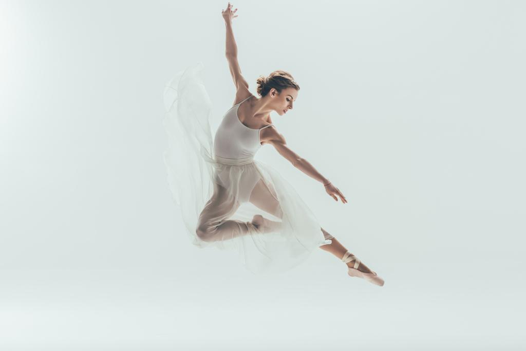 beautiful ballet dancer in white dress jumping in studio, isolated on white - Photo, Image