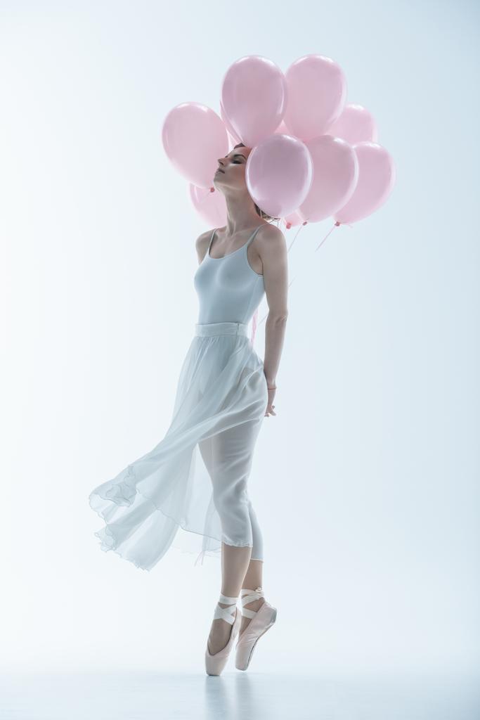 tierna bailarina de ballet en vestido blanco con globos rosados, aislada en blanco
 - Foto, imagen