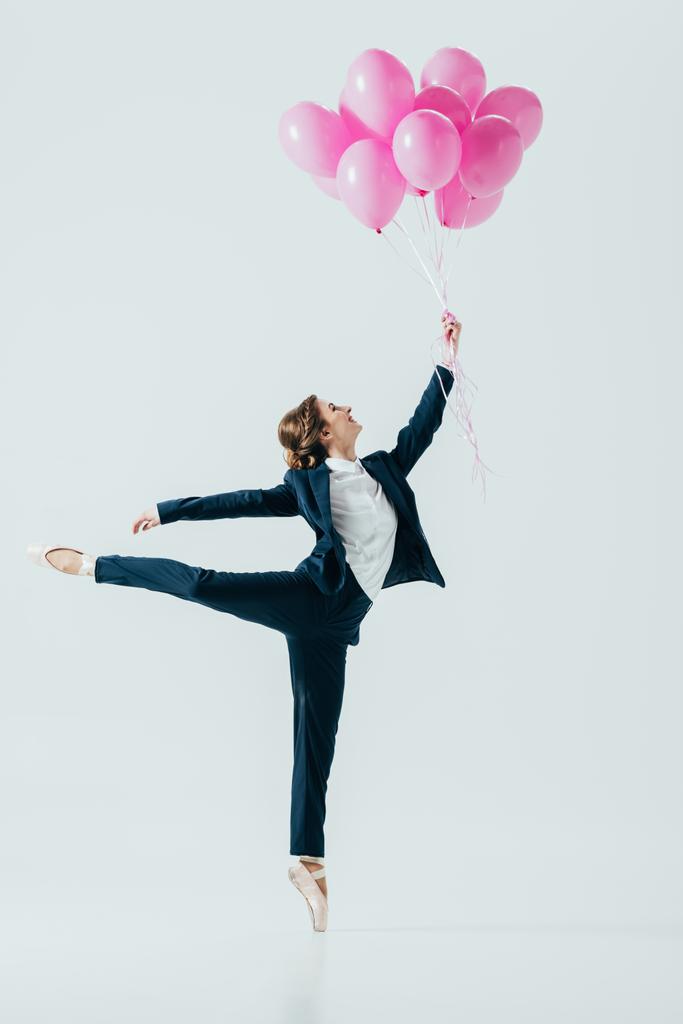 businesswoman in suit and ballet shoes holding pink balloons, isolated on grey - Photo, Image