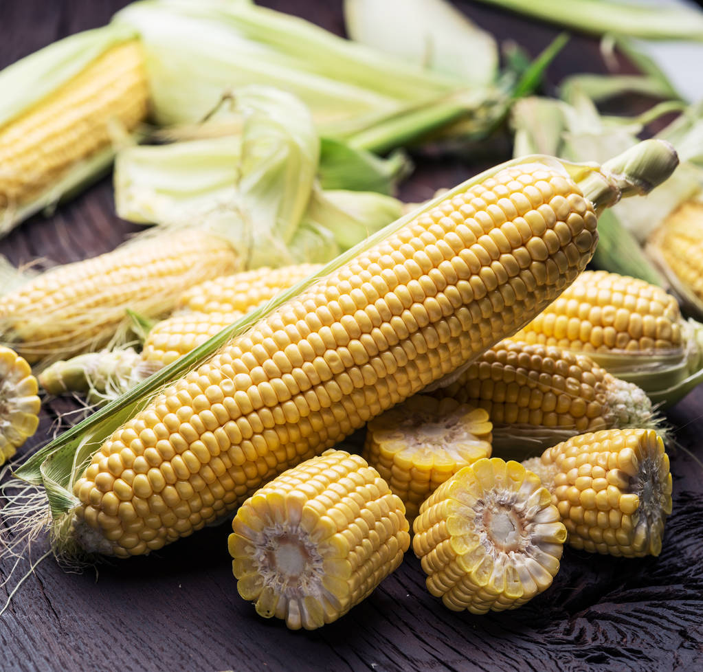 Вухо кукурудзи або кукурудзи на темному дерев'яному фоні
. - Фото, зображення
