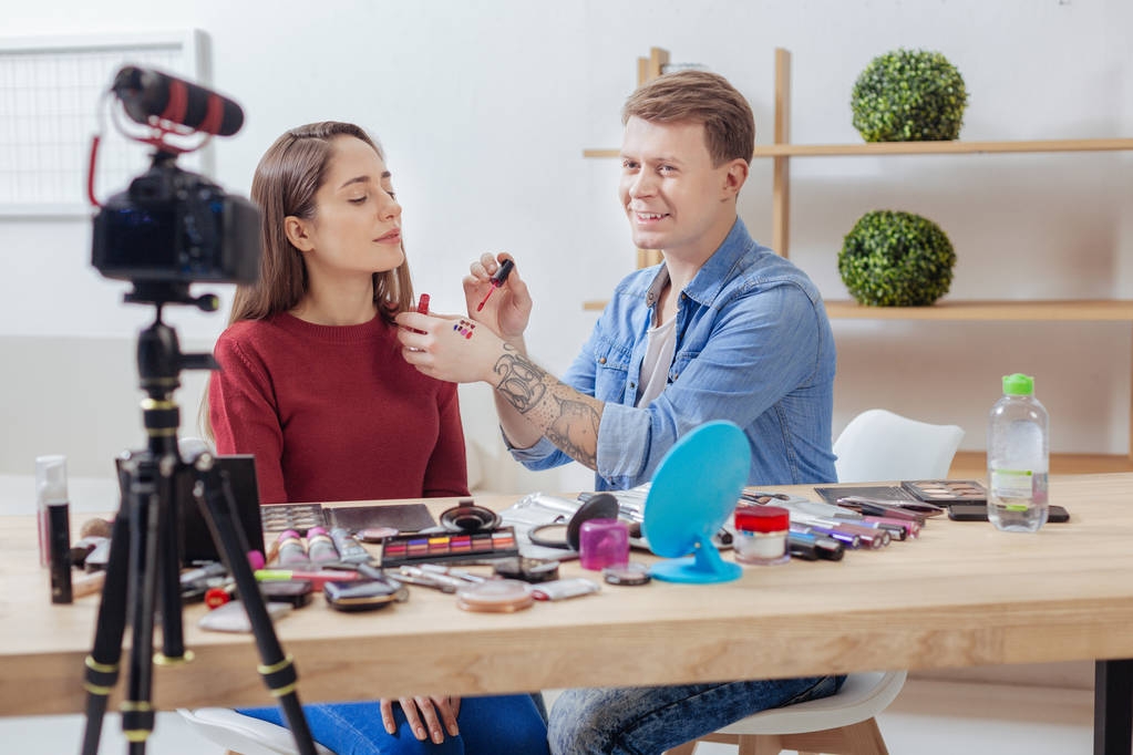 Gekwalificeerde fashion blogger zitten met zijn vriend en testen van alle de lippenstiften - Foto, afbeelding