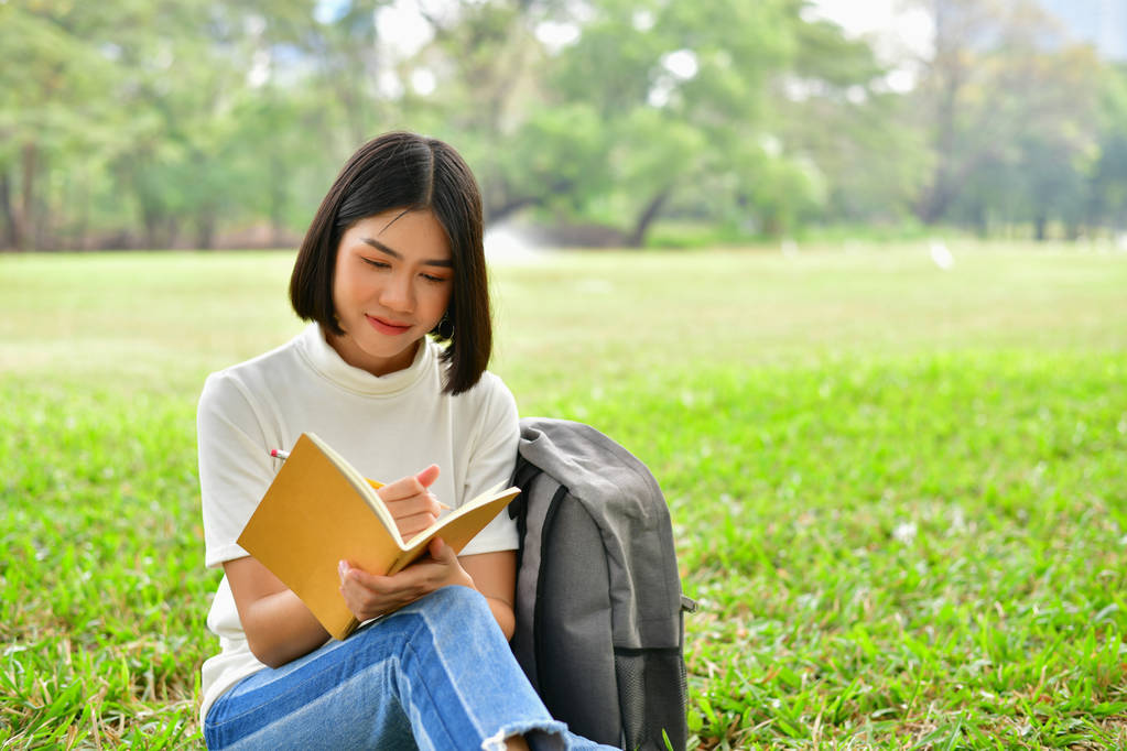 Conceptos educativos. Mujeres asiáticas leyendo libros en el parque. Beaut.
 - Foto, Imagen
