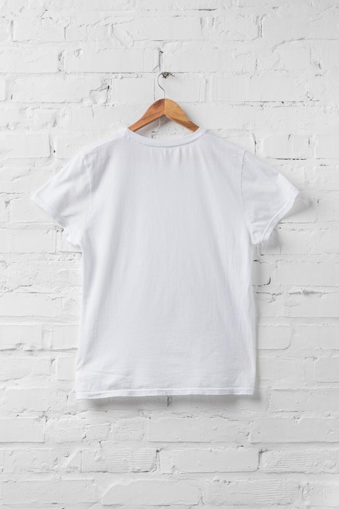 une chemise blanche sur cintre sur mur blanc
 - Photo, image