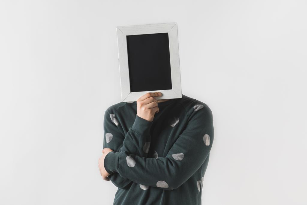 muž pokrývající obličej s černou deskou izolované na bílém - Fotografie, Obrázek