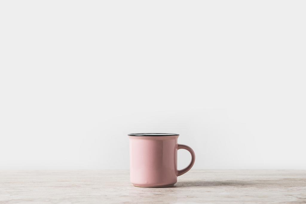 una taza rosa sobre mesa de mármol sobre blanco
 - Foto, Imagen