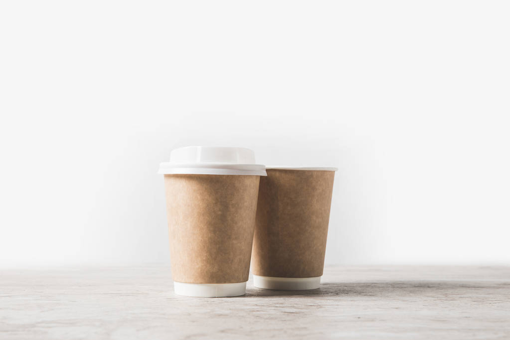 filiżanki kawy jednorazowe na marmurowym stoliku na białym  - Zdjęcie, obraz