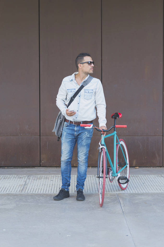Um homem de negócios elegante com telefone celular com bicicleta retro
 - Foto, Imagem