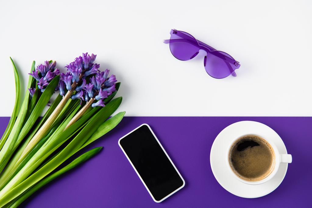 vista dall'alto di bouquet di fiori di giacinto viola e smartphone sul tavolo
 - Foto, immagini
