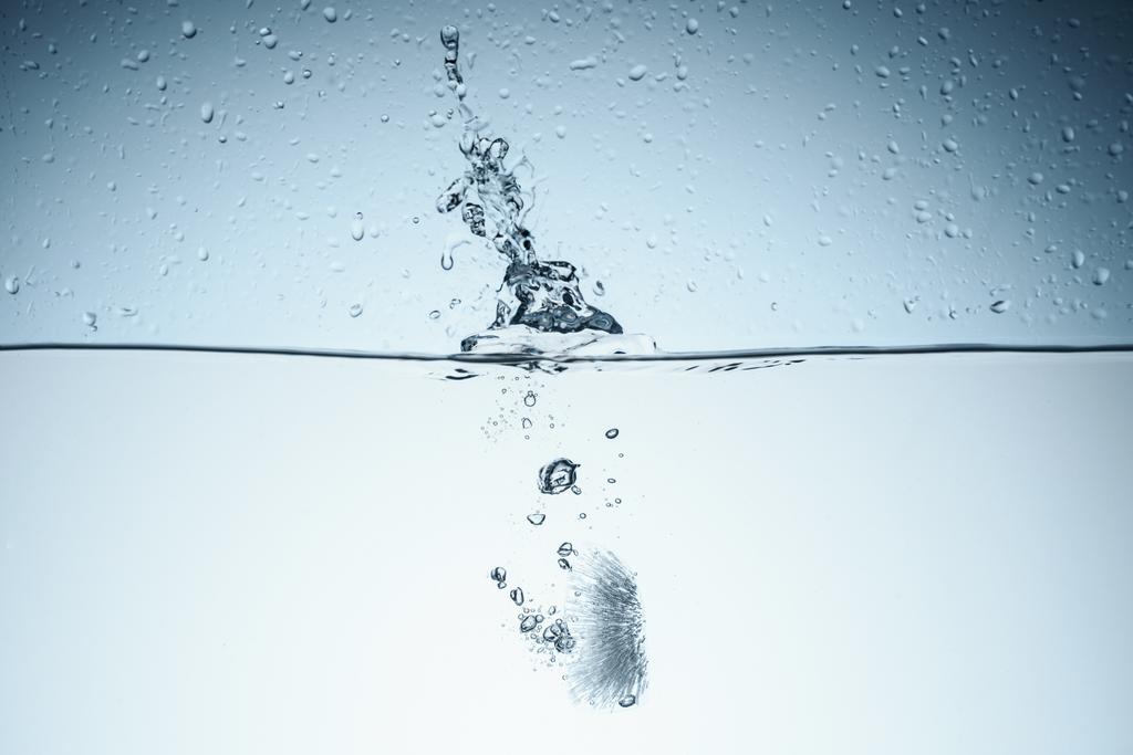 крижаний куб у воді з бризкою, ізольований на білому
 - Фото, зображення