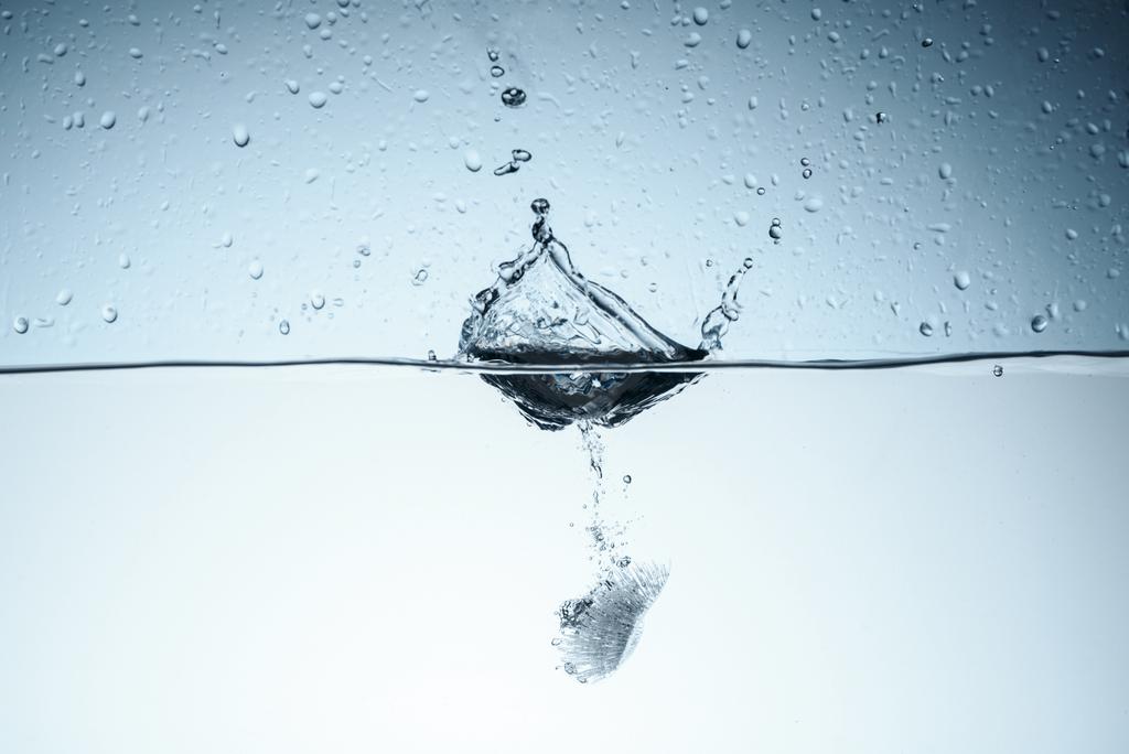 кубик льда в чистой воде с брызгами, изолированные на белом
 - Фото, изображение