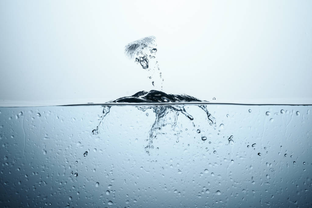 Eiswürfel in reinem Wasser mit Spritzwasser, isoliert auf weiß - Foto, Bild
