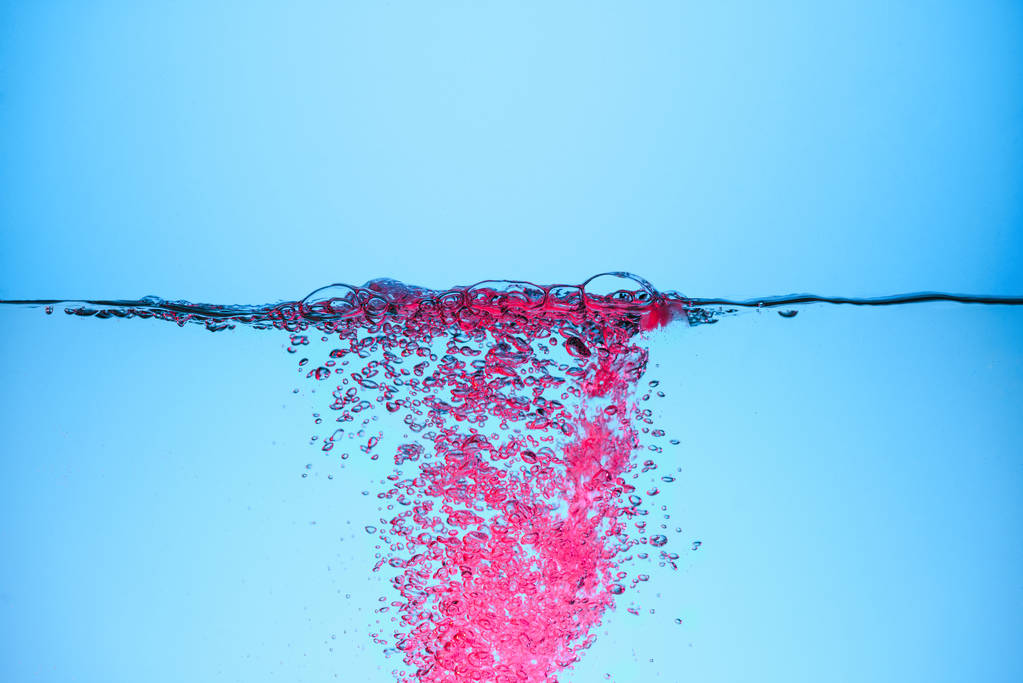 pink bubbles in water, isolated on blue - Photo, Image