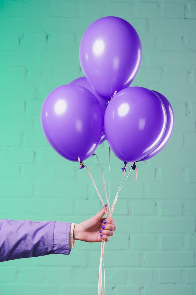abgeschnittene Aufnahme einer Frau mit lila Heliumballons - Foto, Bild