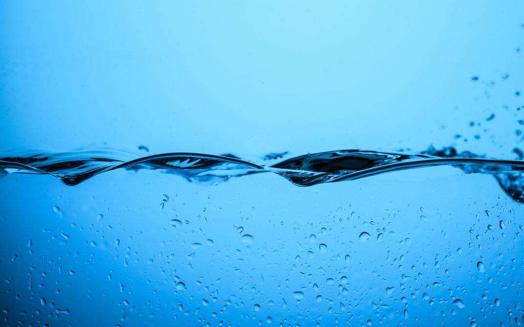 flowing water texture with drops, isolated on blue - Photo, Image