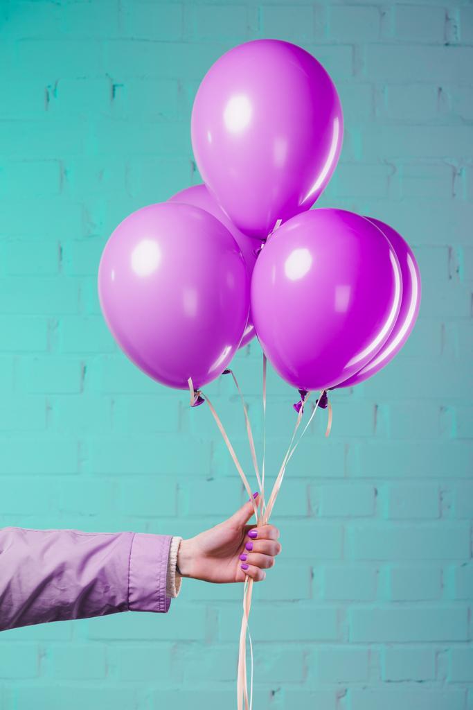 rajattu laukaus nainen tilalla vaaleanpunainen helium ilmapalloja
 - Valokuva, kuva