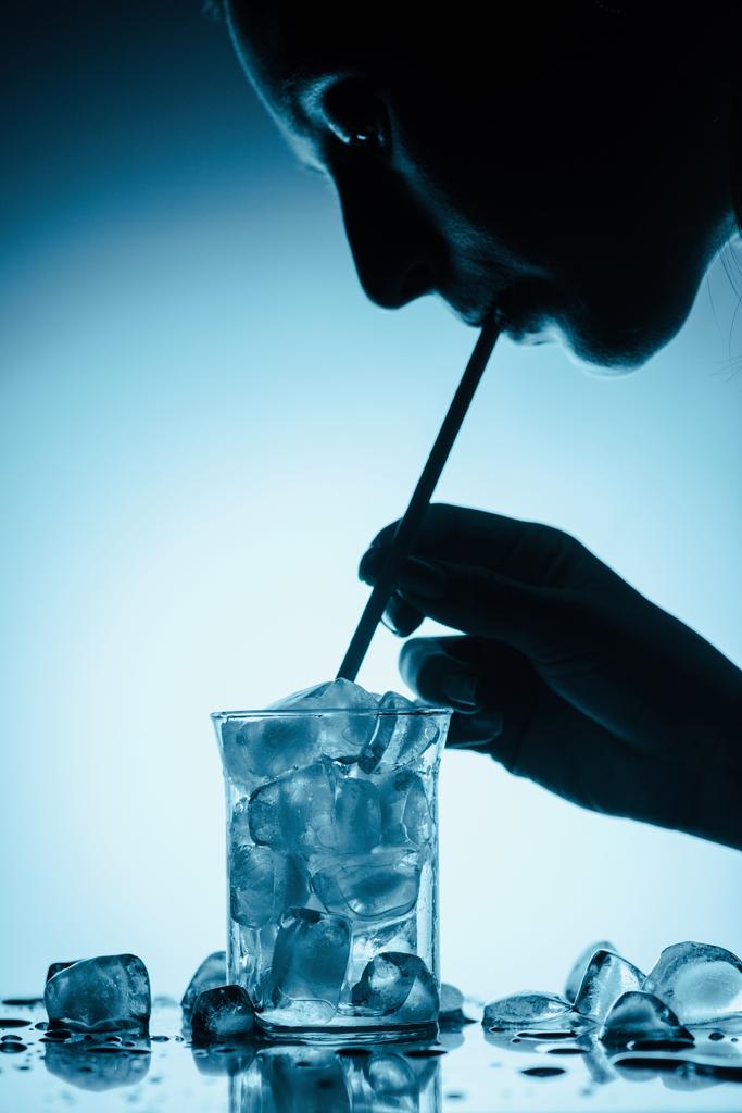 silueta profilu ženy pít studenou vodu s kostkami ledu se slámou - Fotografie, Obrázek