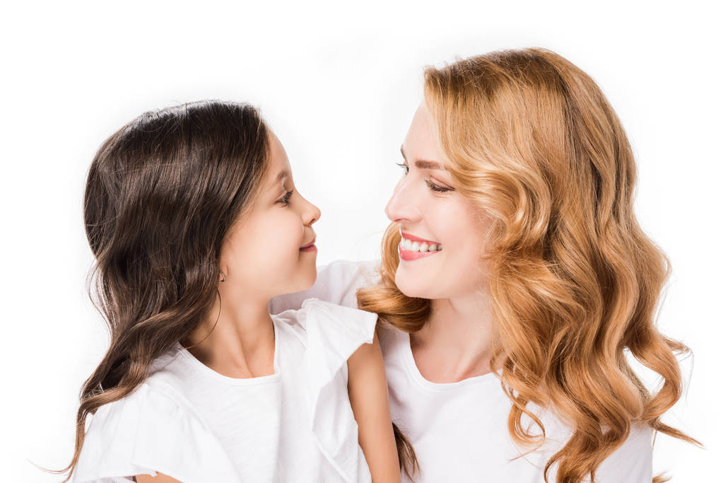 портрет улыбающейся дочери и матери, смотрящих друг на друга изолированно на белом
 - Фото, изображение