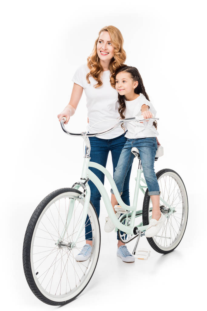 Lächeln Frau und Tochter auf Retro-Fahrrad isoliert auf weiß - Foto, Bild