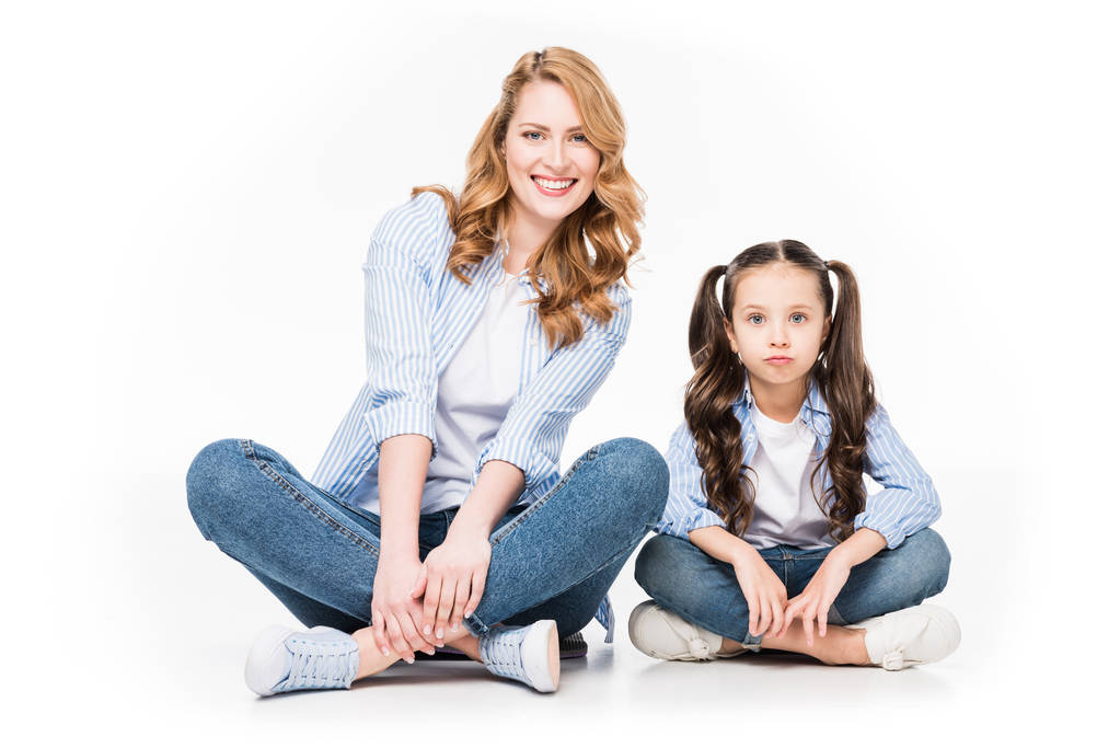 portrait of smiling mother and daughter in denim clothing looking at camera isolated on white - Photo, Image