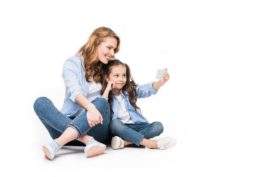 heureux mère et fille prendre selfie sur smartphone ensemble isolé sur blanc
 - Photo, image