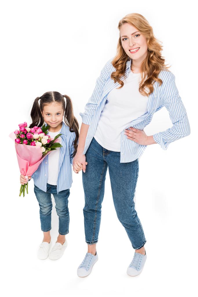 glückliche Mutter und kleine Tochter mit Blumenstrauß, Händchen haltend auf weißem, Muttertagsferienkonzept - Foto, Bild