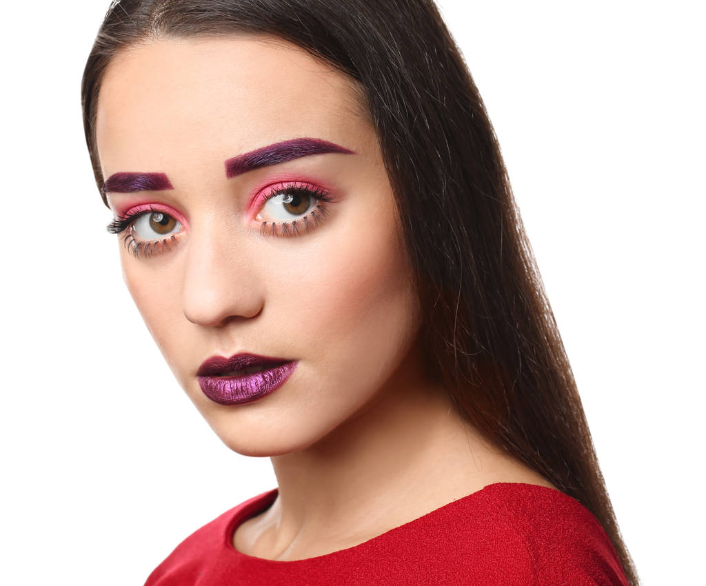 Young woman with dyed eyebrows and creative makeup on white background - Photo, Image