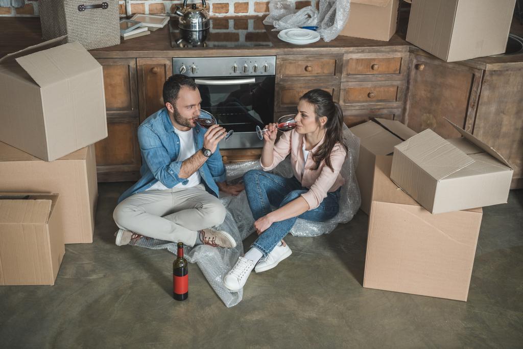 високий кут зору молодої пари, що п'є вино і святкує переїзд в новій квартирі
  - Фото, зображення