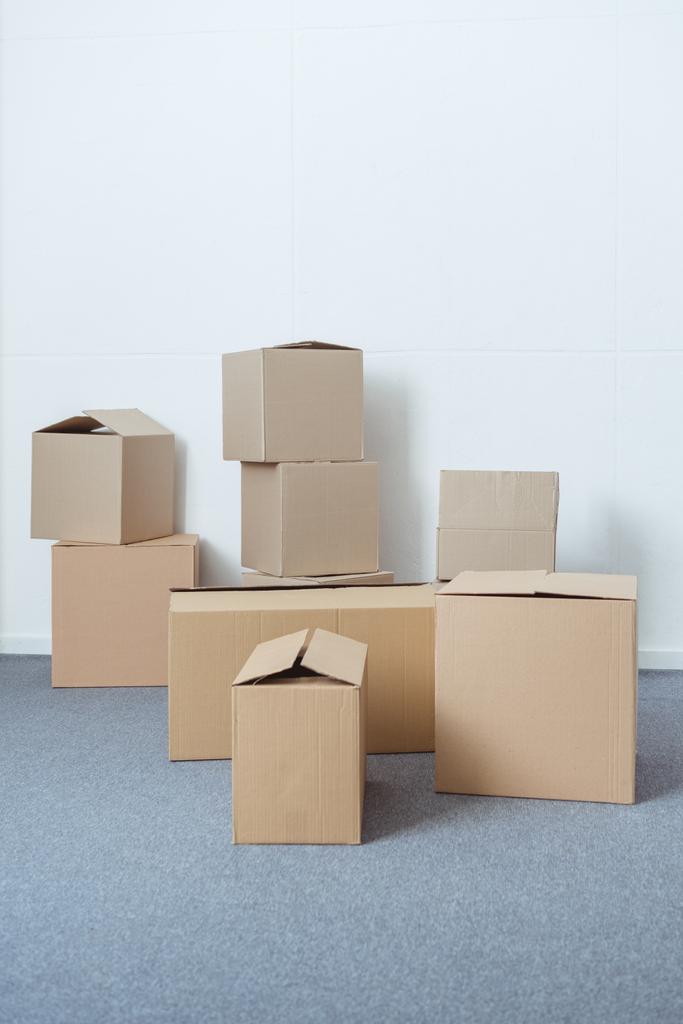 складені картонні коробки у порожній кімнаті під час переміщення
 - Фото, зображення