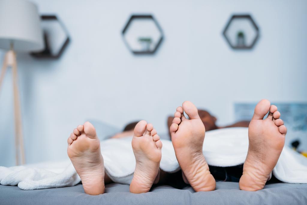 multikulturális pár alatt takaró az ágyban fekvő - Fotó, kép