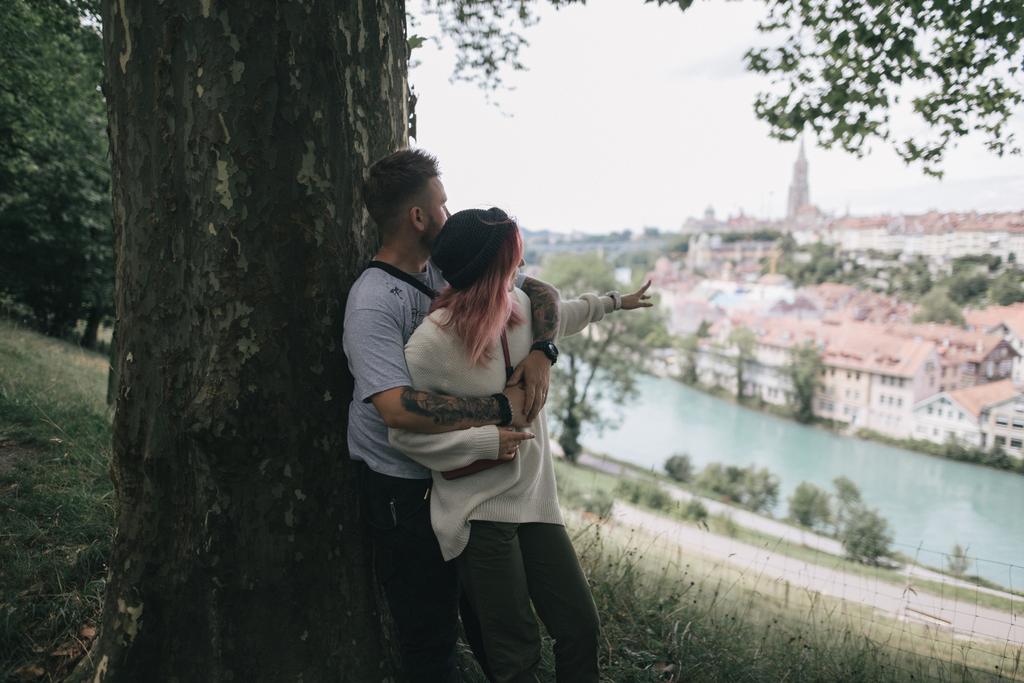 jeune couple amoureux étreignant près de grand arbre et regardant le paysage urbain bernois
 - Photo, image