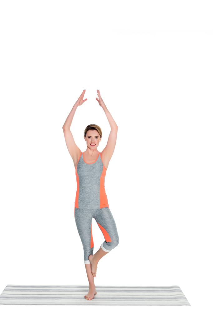 Frau in Sportkleidung praktiziert Yoga-Baum Pose isoliert auf weiß - Foto, Bild