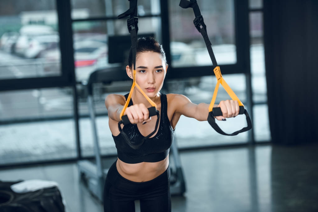 привлекательная женщина, работающая с подвесными ремнями в спортзале
 - Фото, изображение