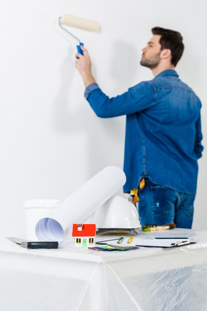 άνθρωπος ζωγραφική τοίχου με βαφή ρολό πινέλο - Φωτογραφία, εικόνα