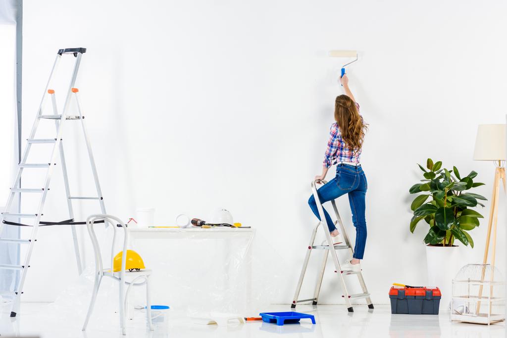 vista posteriore della ragazza in piedi su scala e parete di pittura
 - Foto, immagini