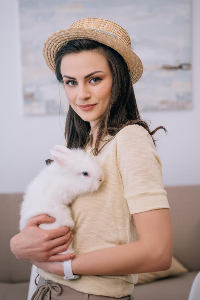 junge stilvolle Frau mit Hut und niedlichem weißen Kaninchen - Foto, Bild